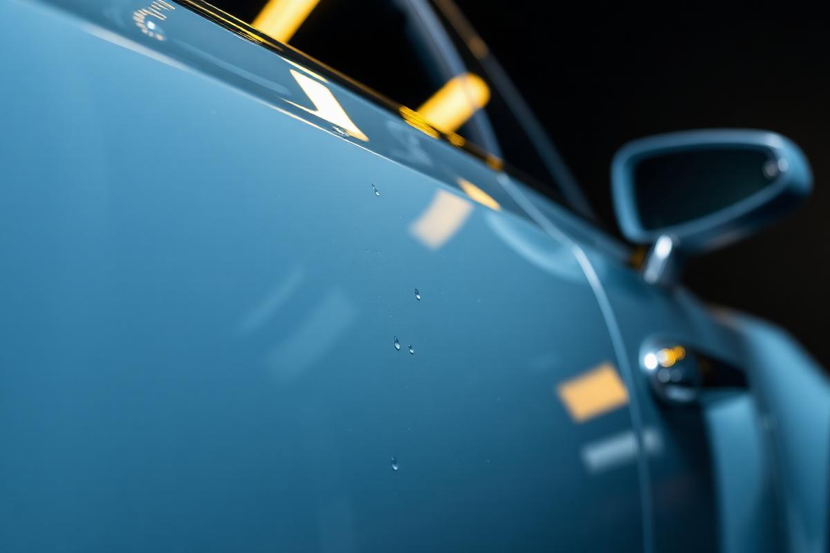 Mirror-gloss car paint with water beading after premium mobile exterior detailing and sealant